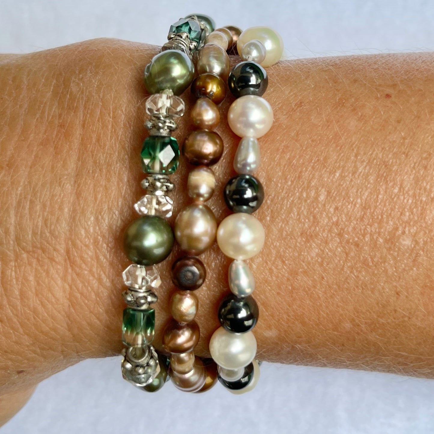 green bronze grey pearl bracelets on arm